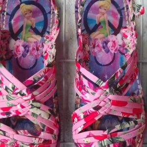 Children's pink floral sandals with crisscross straps and a princess illustration on the footbed.